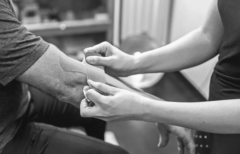 Dirsek çevresine bant uygulaması; temsili stok fotoğraf